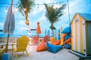 hermosa vista de la playa al atardecer con sillas coloridas para relajarse foto