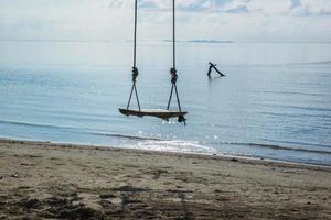 Wooden swing on the beach for holiday background photo