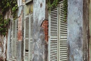 Old broken walls with old wooden windows from abandoned house photo