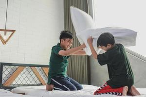 Naughty boy staged a pillow fight on the bed in the bedroom photo