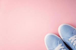 Female sneakers with laces on pink background with copy space. Lifestyle healthy concept photo