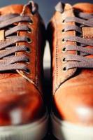 pair of brown male shoes with laces as background close up, selective focus photo