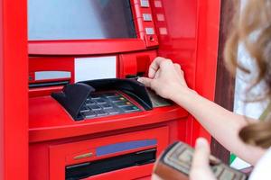 woman uses a credit card at ATM close up photo