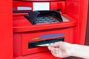 Woman's hand takes cash USD from red ATM photo