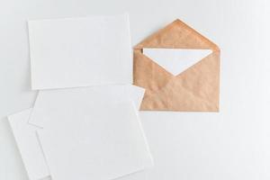 mockup brown kraft envelope and enpty cards on white background photo