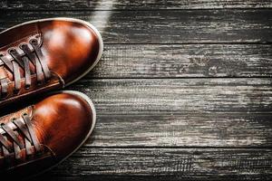 Brown shoes on wooden background top view with copy space photo