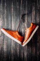 brown leather men's boots hang nails on dark background photo