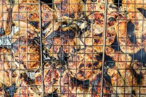 Grilled chicken pieces on barbecue photo