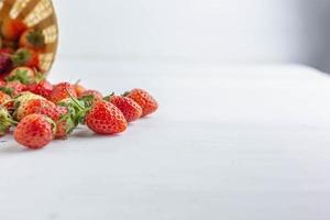 fresas frescas en una cesta sobre un fondo blanco foto