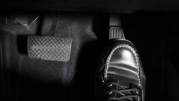 Accelerate and Brake. Foot pressing foot pedal of a car to drive ahead. photo