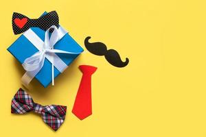 Happy Fathers Day. Top view of gifts box, bow tie, false mustache with copy space. Fathers Day celebration concept photo