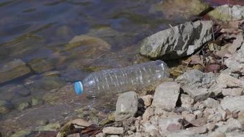 Plastic water bottle in the stream in the forest. environmental conservation concept video