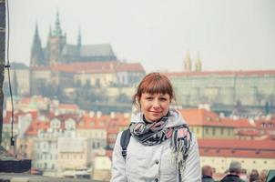 Close-up portrait of young caucasian girl tourist looking at camera and smile, Prague Castle photo