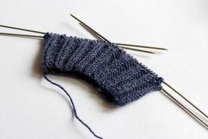 Yarn and knitting needles on white background. Handmade process