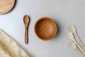 utensilios de madera en la mesa de la cocina. platos redondos de madera, una cuchara de madera. el concepto de servir, cocinar, detalles interiores. vista superior foto