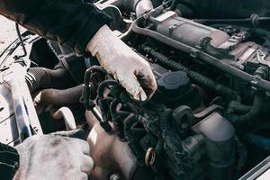 Auto mechanic repairs car engine. photo