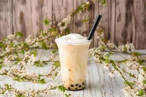 té de leche de taiwán con burbujas sobre fondo de madera foto