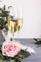 Composition with glasses of vine and flowers on grey concrete background. photo