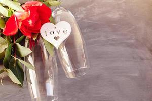 Composition with glass for champagne. Flowers and hearts on grey concrete background. photo