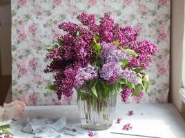 Bouquet of violet lilac in a vase. Still life with blooming branches of lilac in vases. photo