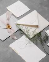 Wedding details flat lay. Wedding invitation and scroll paper. Bottle with fragrance. Ring box. Simple bouquet. photo