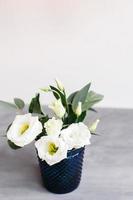 flores blancas en cristal azul clásico. lisianthus Eustoma foto