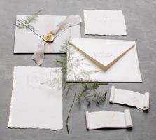 Wedding details flat lay. Wedding invitation and scroll paper. Bottle with fragrance. Ring box. Simple bouquet. photo