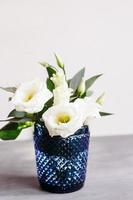 flores blancas en cristal azul clásico. lisianthus Eustoma foto