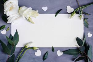 Blank paper copy space. Frame with flowers. Silk ribbon. Gray background. Simple bouquet. Greeting card.