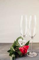 Composition with glass for champagne. Flowers and hearts on grey concrete background.
