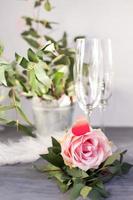 composición con copa para champán. flores y corazones sobre fondo de hormigón gris. foto