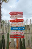 Direcciones de letreros de madera coloridas en un área de playa foto