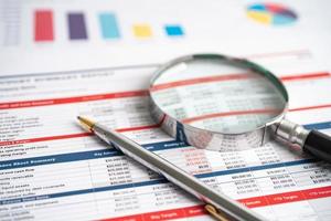 Magnifying glass on charts graphs spreadsheet paper. Financial development, Banking Account, Statistics, Investment Analytic research data economy, Stock exchange trading, Business concept. photo