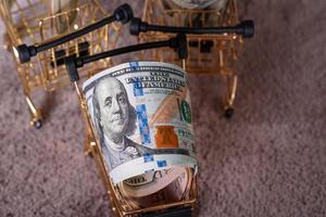 Finance, business and banking. American dollars on a gray cement background. Dollars in a cart. photo