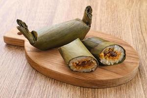 Arem-arem, a traditional Indonesian food made from rice filled with vegetables, chicken, meat or tempeh wrapped in banana leaves. Arem-arem is popular as a breakfast substitute. Selected focus. photo