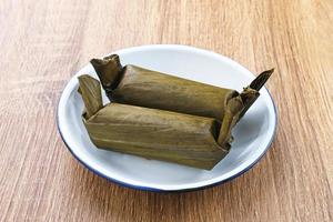 Arem-arem, a traditional Indonesian food made from rice filled with vegetables, chicken, meat or tempeh wrapped in banana leaves. Arem-arem is popular as a breakfast substitute. Selected focus. photo