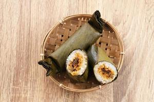 Arem-arem, a traditional Indonesian food made from rice filled with vegetables, chicken, meat or tempeh wrapped in banana leaves. Arem-arem is popular as a breakfast substitute. Selected focus. photo