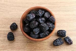 Kurma Ajwa, Ajwa Dates, served in wooden bowl. Kurma Ajwa is one of the special fruit of Arabic. photo