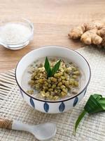 Mung Bean Porridge or Bubur Kacang Hijau, Indonesian dessert porridge of mung beans with coconut milk, pandan leaf and ginger. Served in bowl. photo