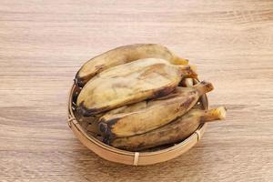 pisang kukus o plátano al vapor, comida tradicional indonesia, un refrigerio saludable. servido en mesa de madera. de cerca. foto