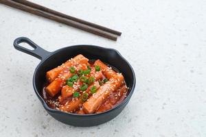 Tteokbokki or Topokki , stir fried rice cake stick, popular Korean street food with spicy gochujang sauce and sesame seed. photo