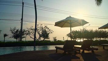 Sonnenschirm mit Bettpool rund um den Pool mit Ozean-Meer-Hintergrund - Urlaubs- und Urlaubskonzept video