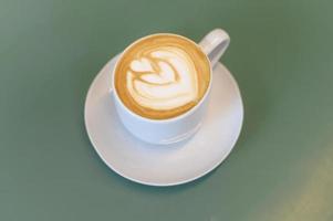 Hot cappuccino with latte art on table photo