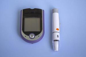 close-up, top view of blood glucose meter, test strips and syringe with copy space isolated on colored background photo