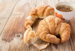 Croissant and coffee for breakfast on wooden table photo