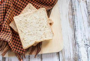 Whole wheat bread on white wooden table photo
