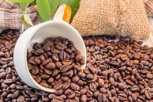 Coffee beans and coffee cup on wooden background photo