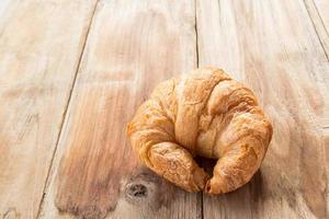 Fresh croissants on old wooden table