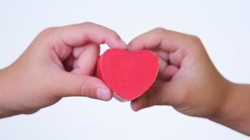 menina segurando um coração vermelho na mão. conceito de caridade e saúde. Dia Internacional da Cardiologia.