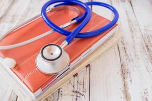 Stethoscope on book on wooden table